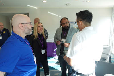 Five attendees talking in a standing group