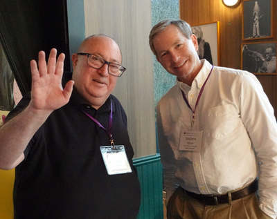 Two attendees posing, one waving at the camera
