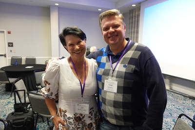 Two attendees posing in a meeting room